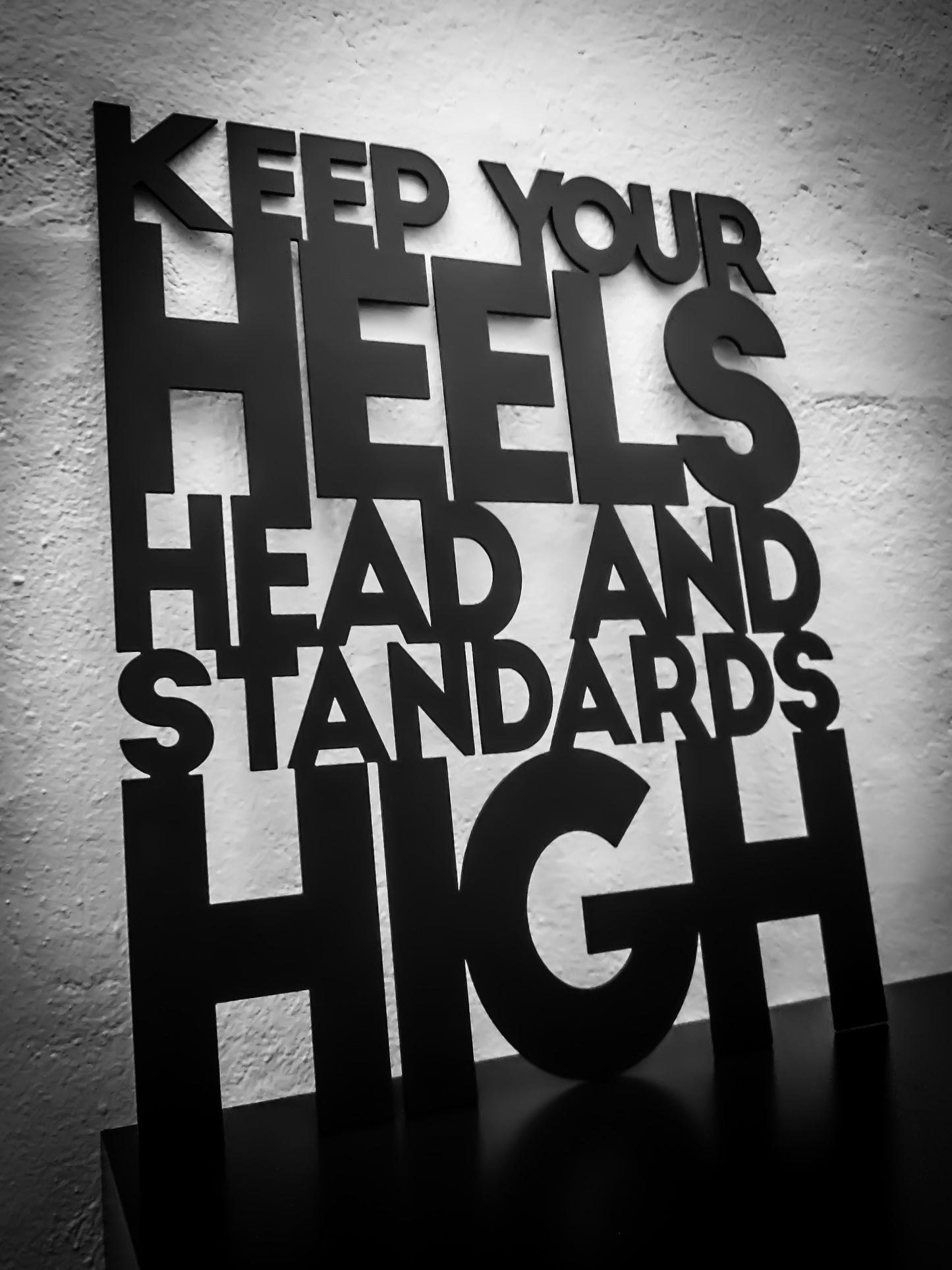 Skilt med tekst - Keep your heels head and standards high